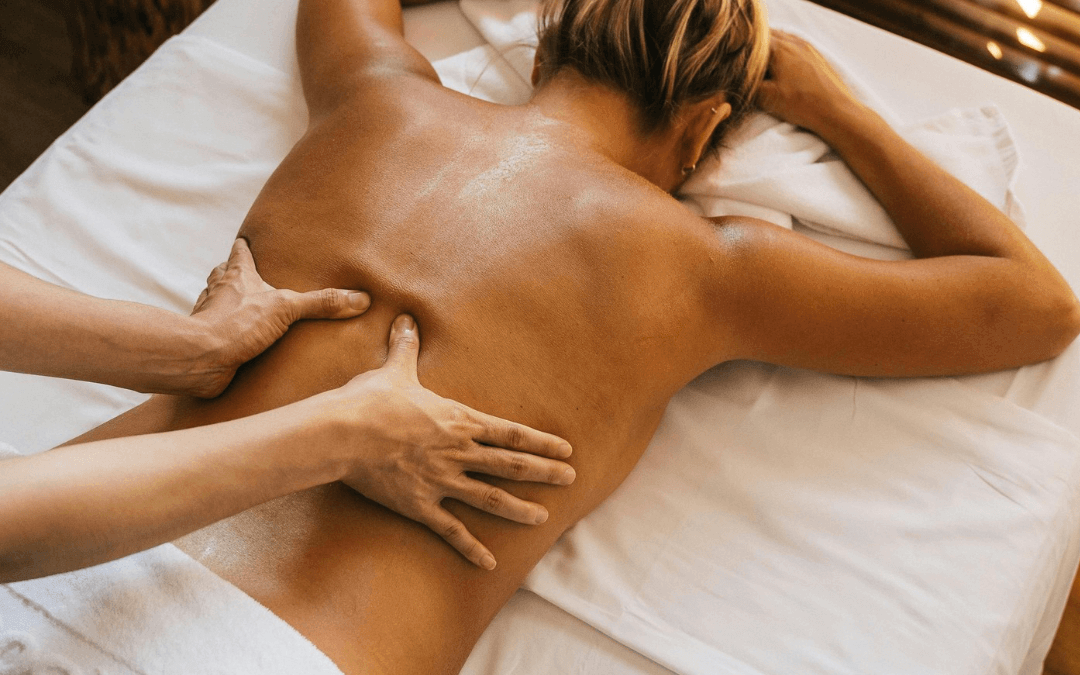 Femme en post-partum recevant un massage relaxant à son domicile dans une ambiance douce et apaisante.