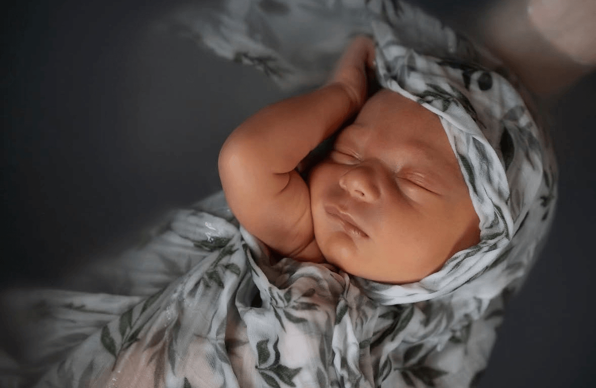 Bain enveloppé pour nouveau-né dans un lange, bébé immergé dans l’eau pour un moment de détente, de sécurité et de bien-être périnatal.