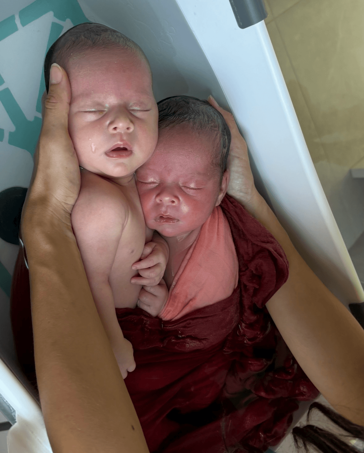 Bain enveloppé de jumelles réalisé à domicile à Tournai en Belgique, bébé apaisé dans l’eau chaude.